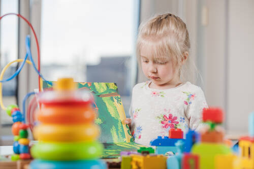 Girl reading book daycare